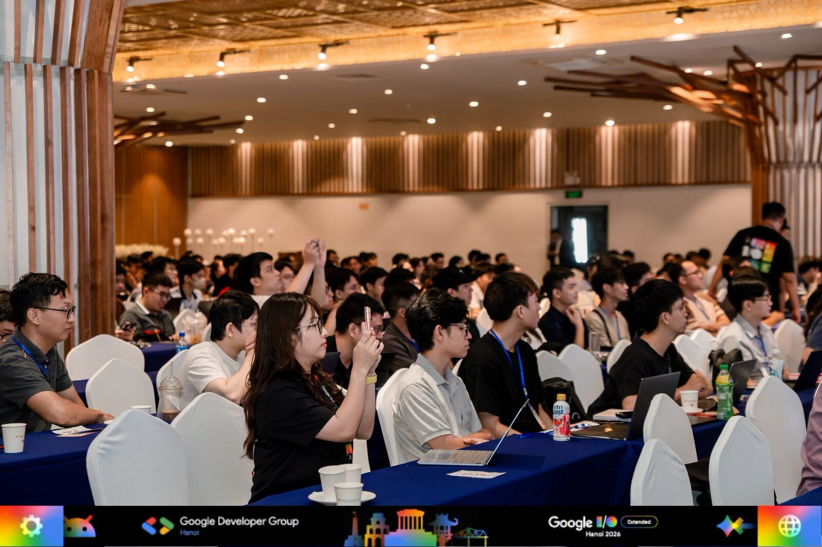 Attendees seated with laptops open during a session