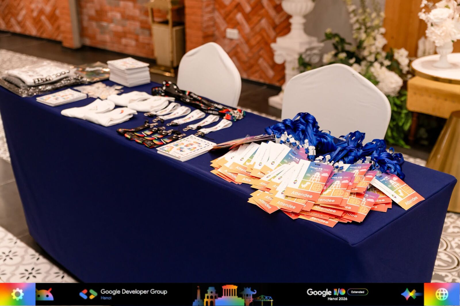 Badges and lanyards laid out on the check-in table at Google I/O Extended Hanoi 2026
